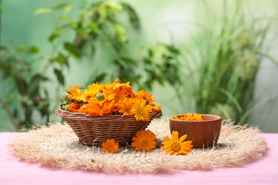 Photo of Many beautiful fresh calendula flowers on table against blurred green background, space for text