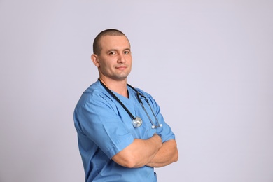 Portrait of medical assistant with stethoscope on color background