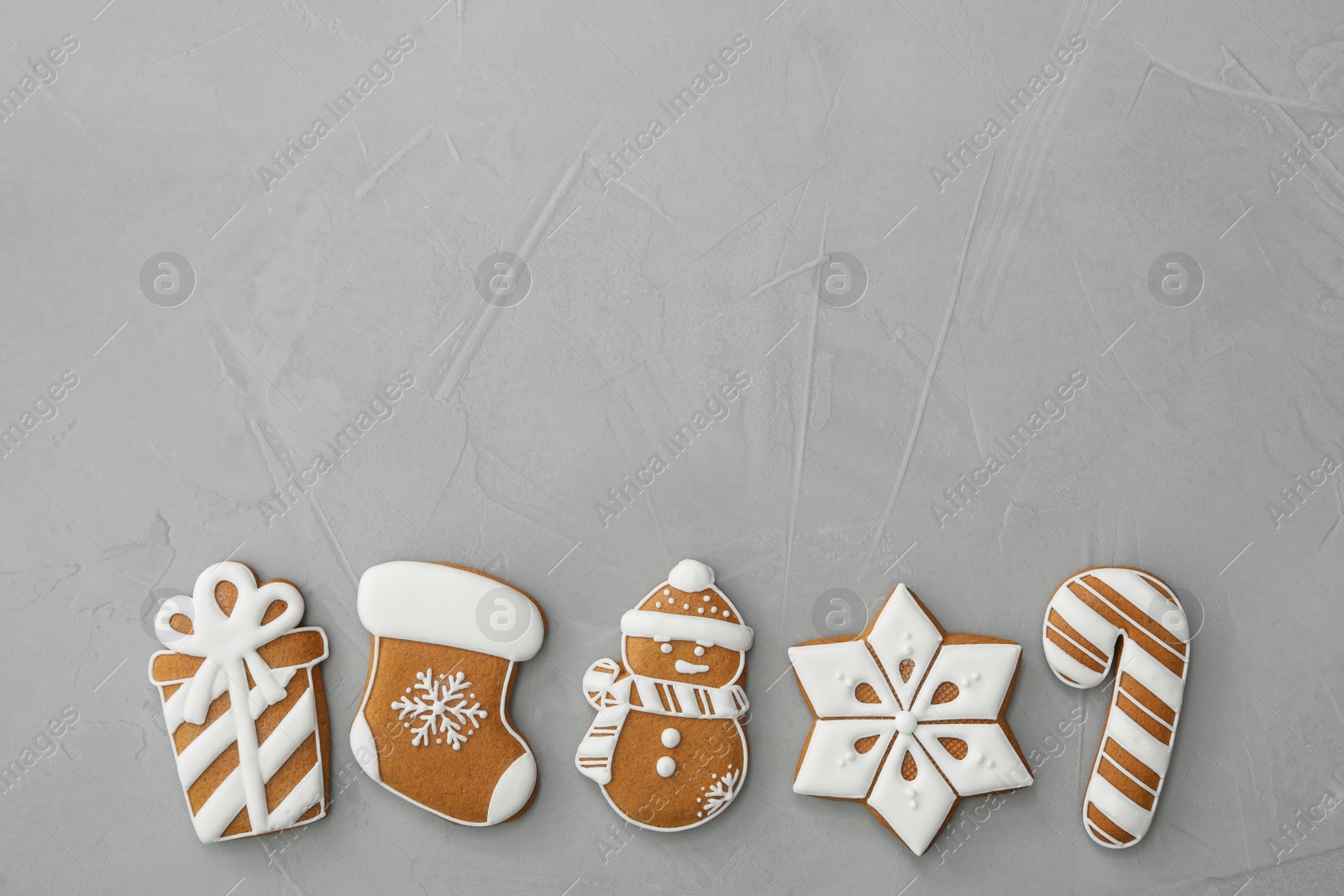 Photo of Different Christmas gingerbread cookies on grey background, flat lay. Space for text
