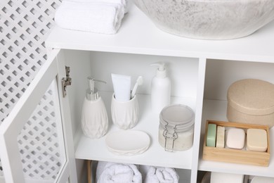 Photo of Different personal care products and bath accessories in bathroom vanity