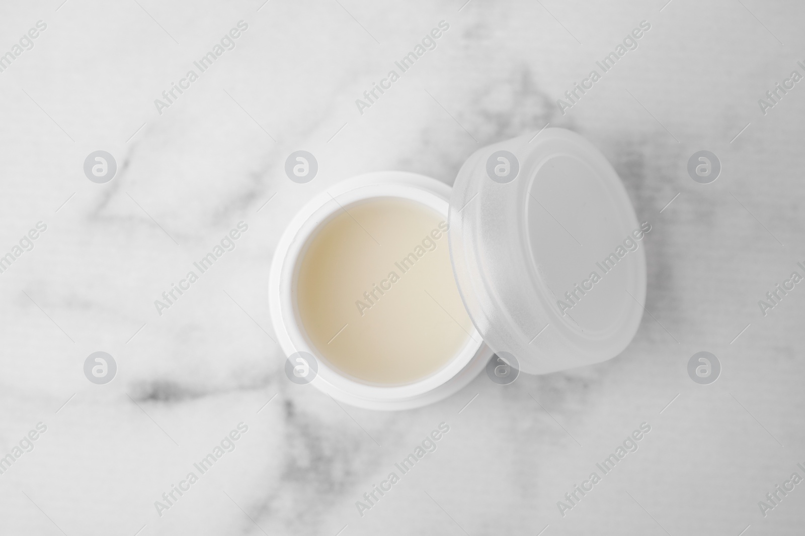 Photo of Jar of petroleum jelly on light gray marble table, top view