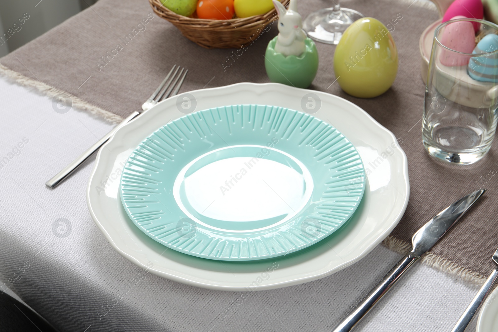 Photo of Easter celebration. Festive table setting with elegant dishware and painted eggs