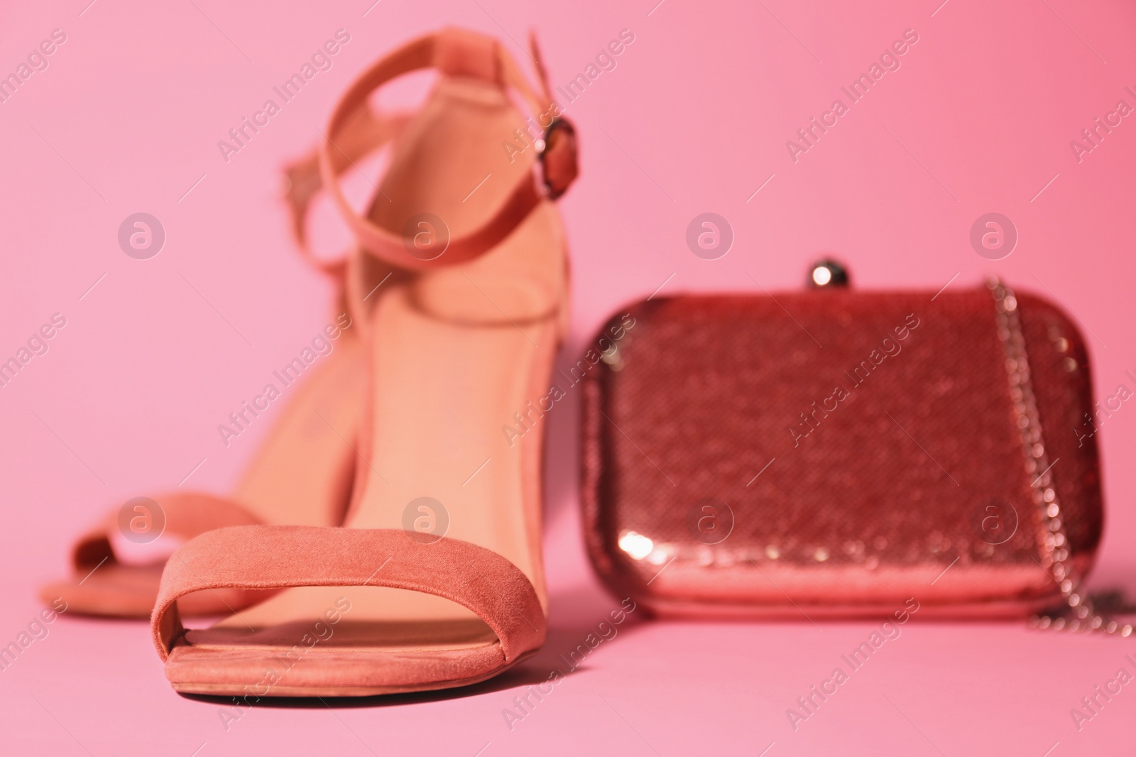 Photo of Stylish shoes and trendy small bag on pink background, closeup