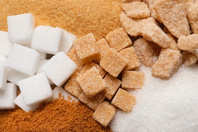 Photo of Different types of sugar as background, closeup