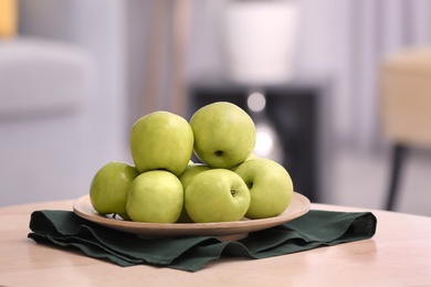 Plate with ripe green apples on table