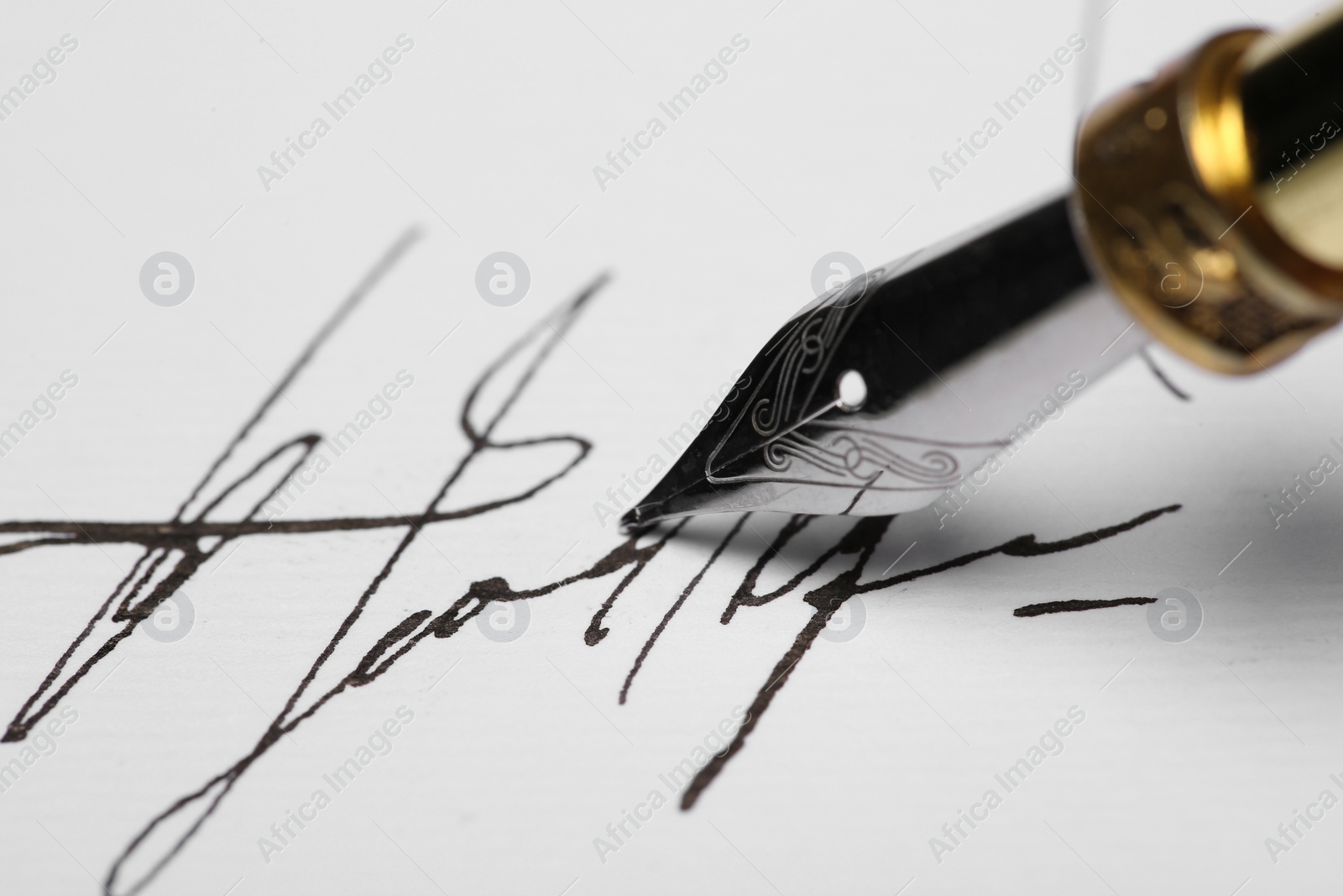 Photo of Signing on sheet of paper with fountain pen, closeup