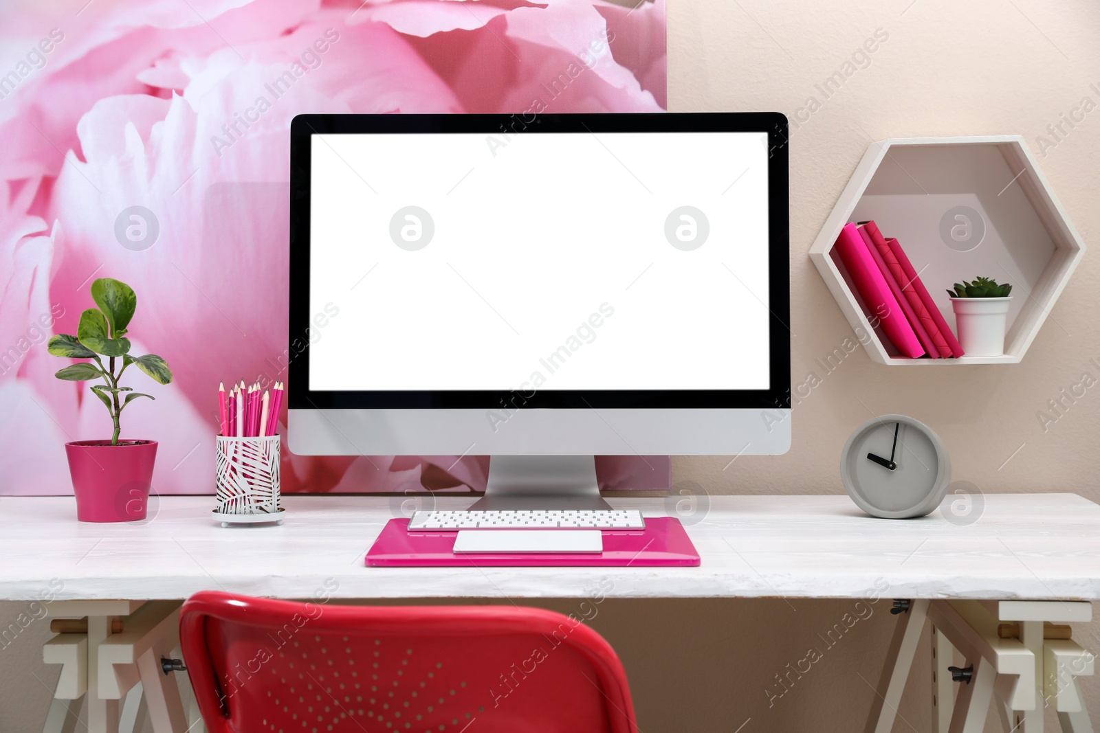 Photo of Stylish workplace with modern computer and pink elements indoors. Space for text