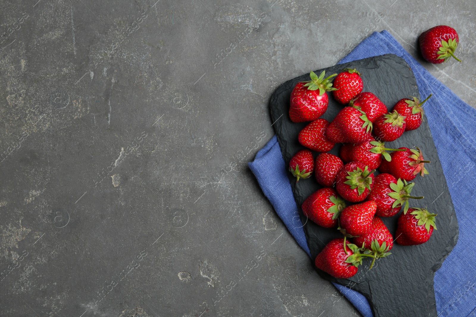 Photo of Delicious ripe strawberries on grey table, flat lay. Space for text