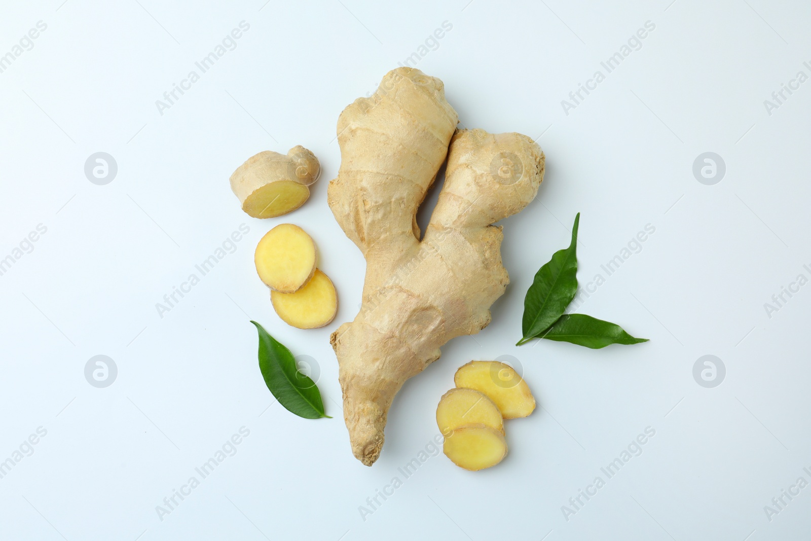 Photo of Fresh ginger with green leaves on white background, flat lay