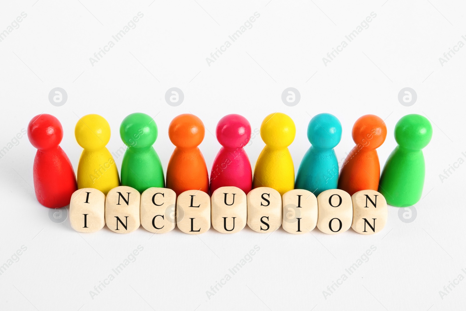 Photo of Colorful pawns and wooden cubes with word Inclusion on white background