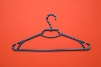 Empty clothes hanger on red background, top view