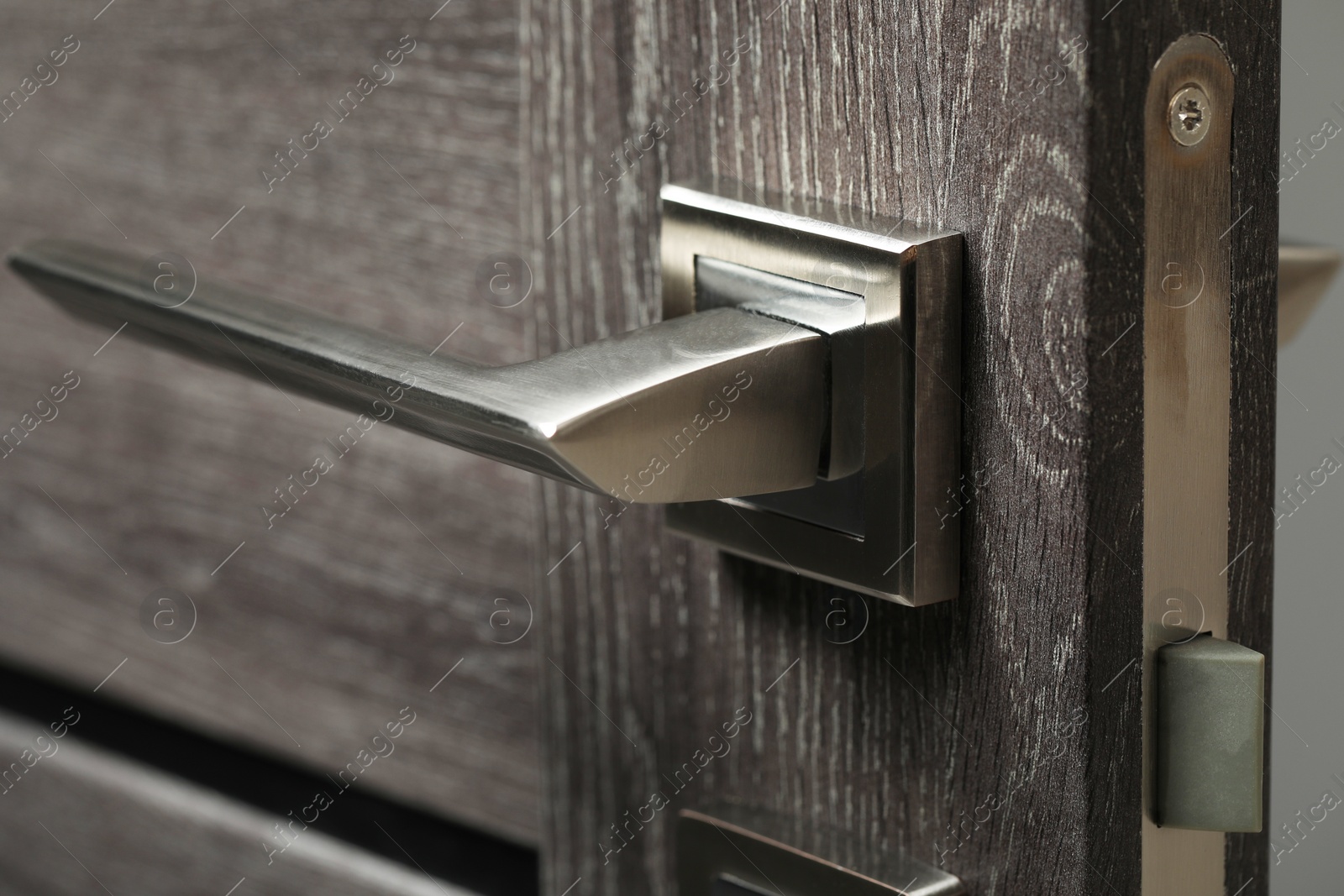 Photo of Open wooden door with metal handle, closeup