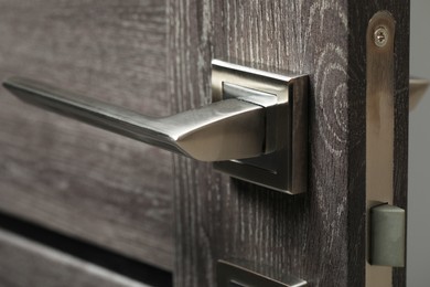 Open wooden door with metal handle, closeup