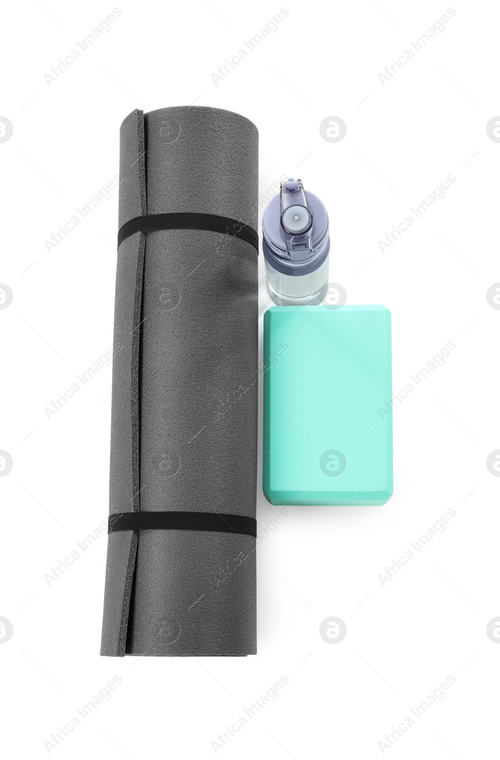 Photo of Grey exercise mat, yoga block and bottle of water isolated on white, top view