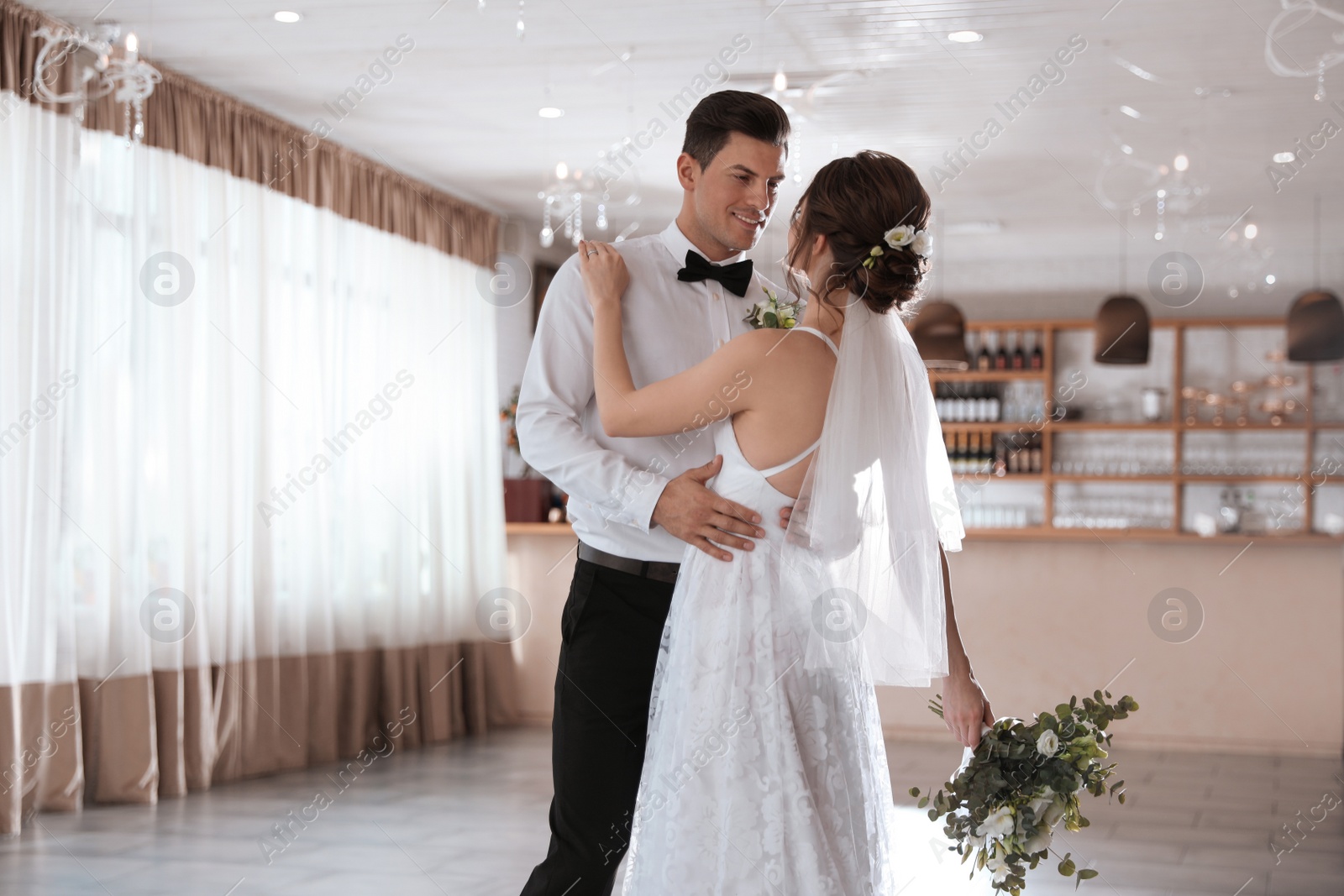 Photo of Happy newlywed couple dancing together in festive hall