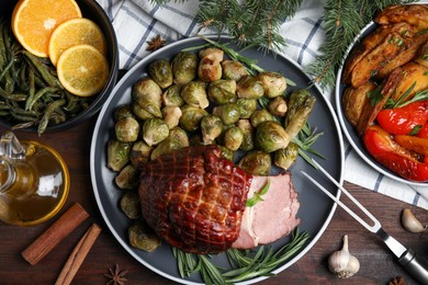 Festive flat lay composition with delicious ham on wooden table. Christmas dinner