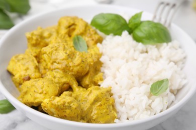 Photo of Delicious rice and chicken with curry sauce in bowl, closeup