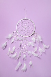 Photo of Beautiful dream catcher on violet background, top view