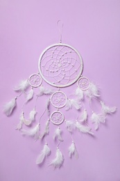 Beautiful dream catcher on violet background, top view