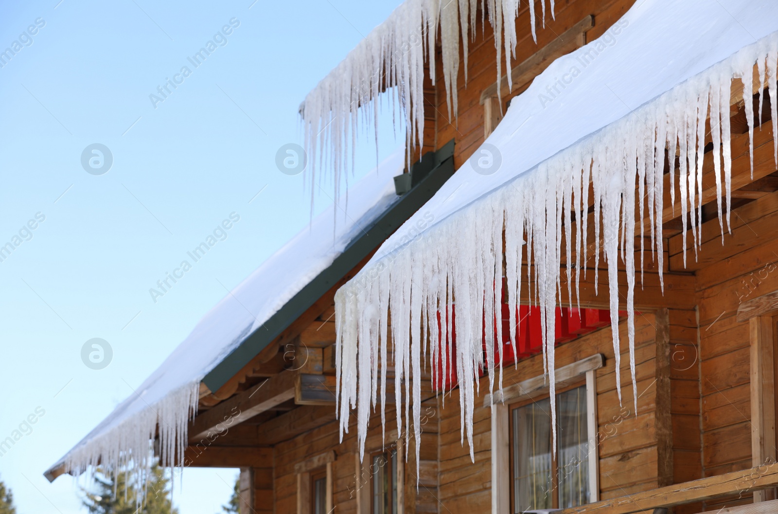 Photo of House with icicles on roof. Winter season