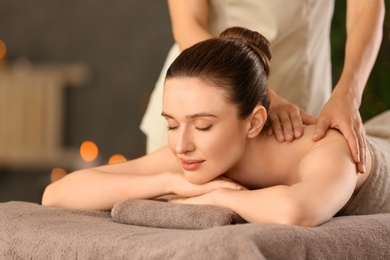 Photo of Beautiful young woman enjoying massage in spa salon