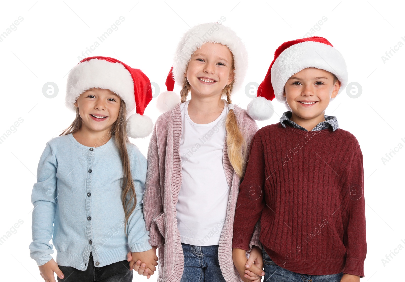 Photo of Happy little children in Santa hats on white background. Christmas celebration