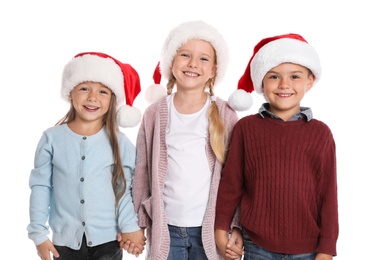 Photo of Happy little children in Santa hats on white background. Christmas celebration