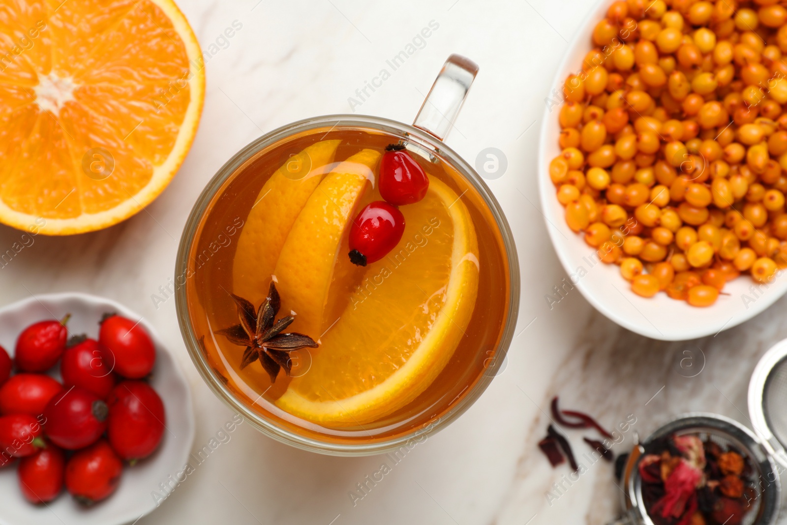 Photo of Immunity boosting drink and ingredients on white marble table, flat lay