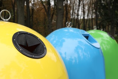 Photo of Waste sorting bins in park on autumn day, closeup