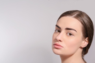 Photo of Beautiful woman with perfect eyebrows on light background