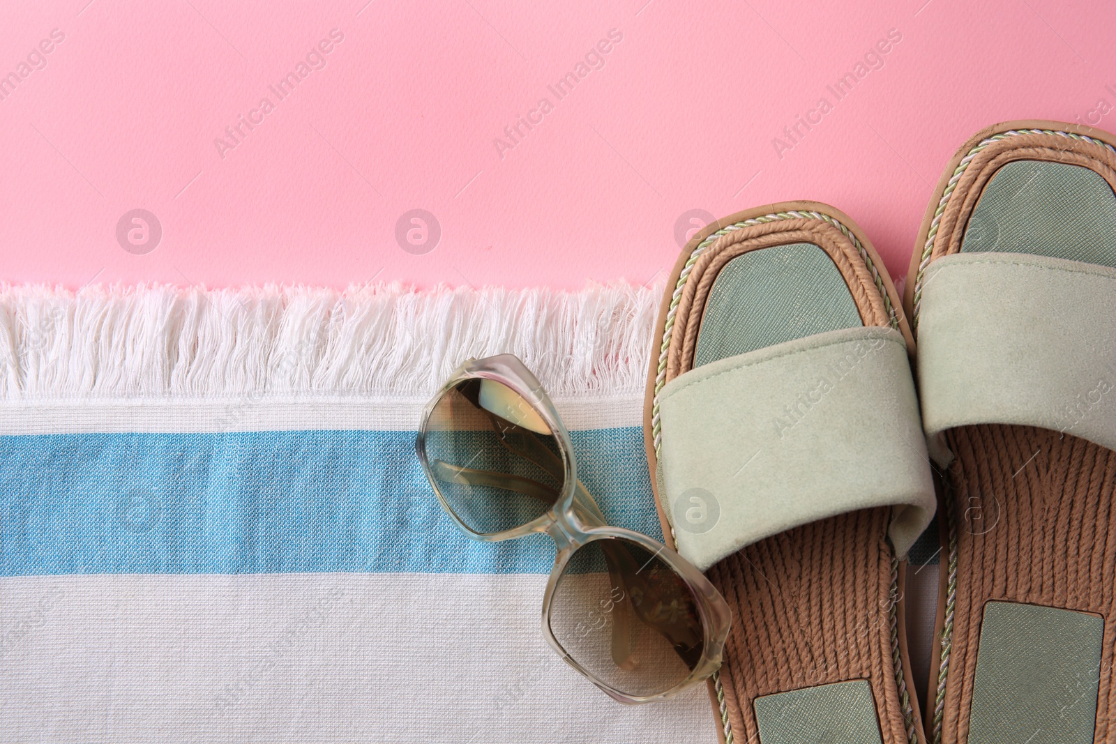 Photo of Flat lay composition with beach accessories on pink background, space for text