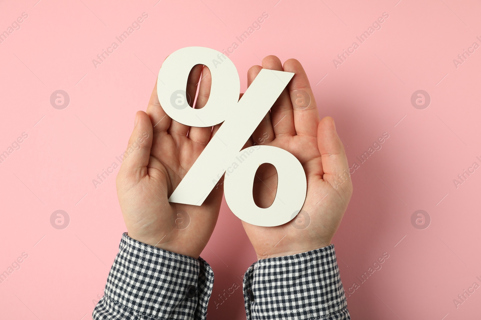 Photo of Man holding percent sign on pink background, top view