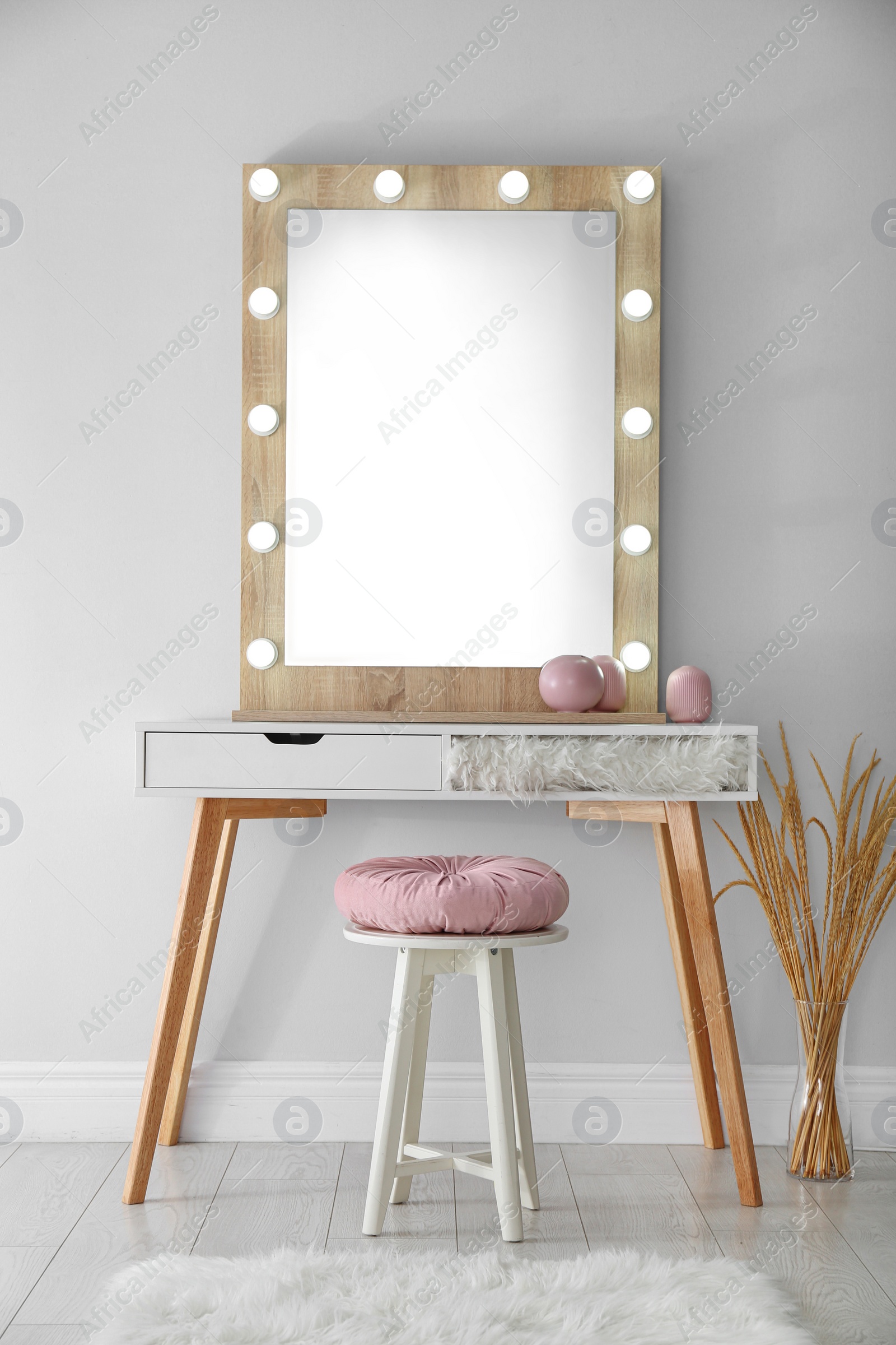 Photo of Stylish mirror with lamps near light wall in room