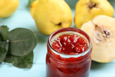 Photo of Delicious quince jam on light blue table, closeup