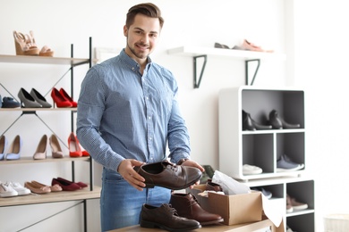 Young man choosing shoes in store