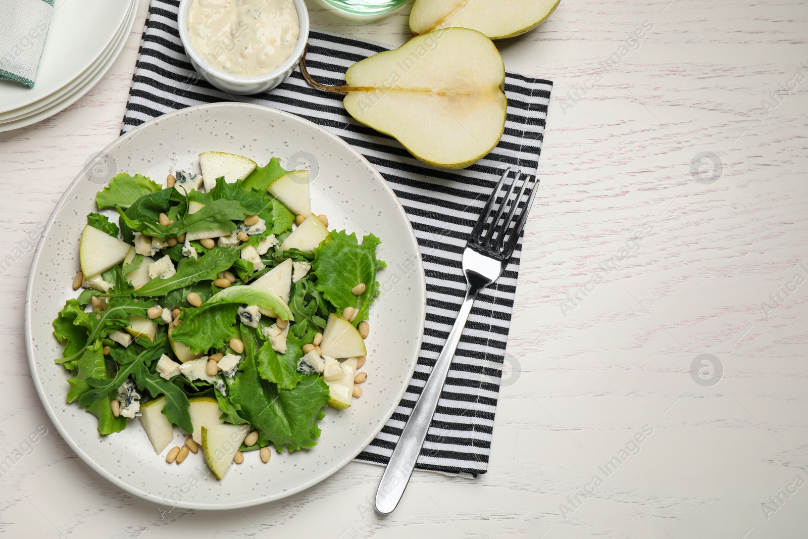 Photo of Tasty salad with pear slices served on white wooden table, flat lay. Space for text