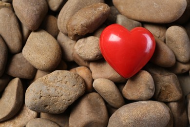 Photo of One red decorative heart on stones, above view
