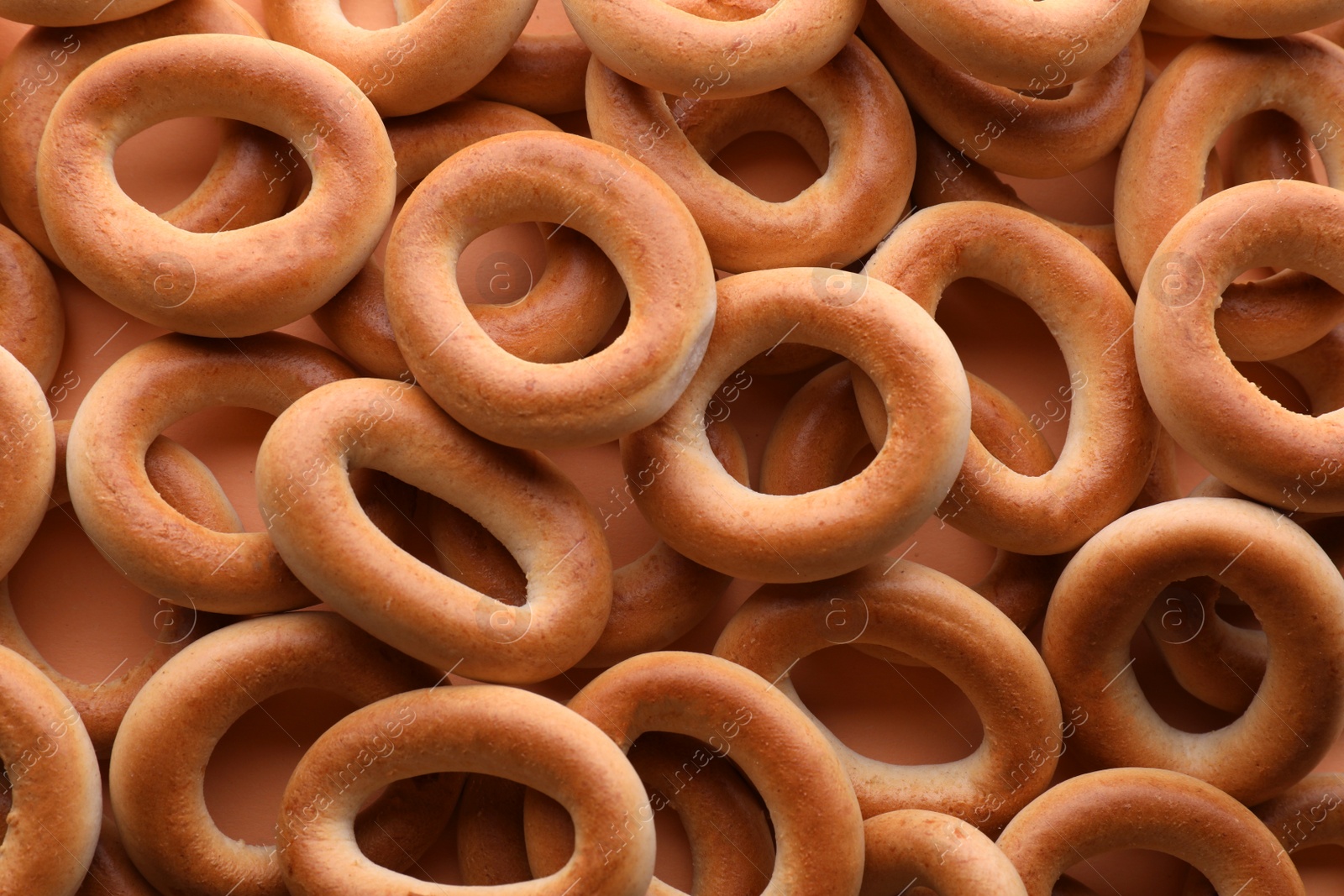 Photo of Many tasty dry bagels (sushki) as background, top view