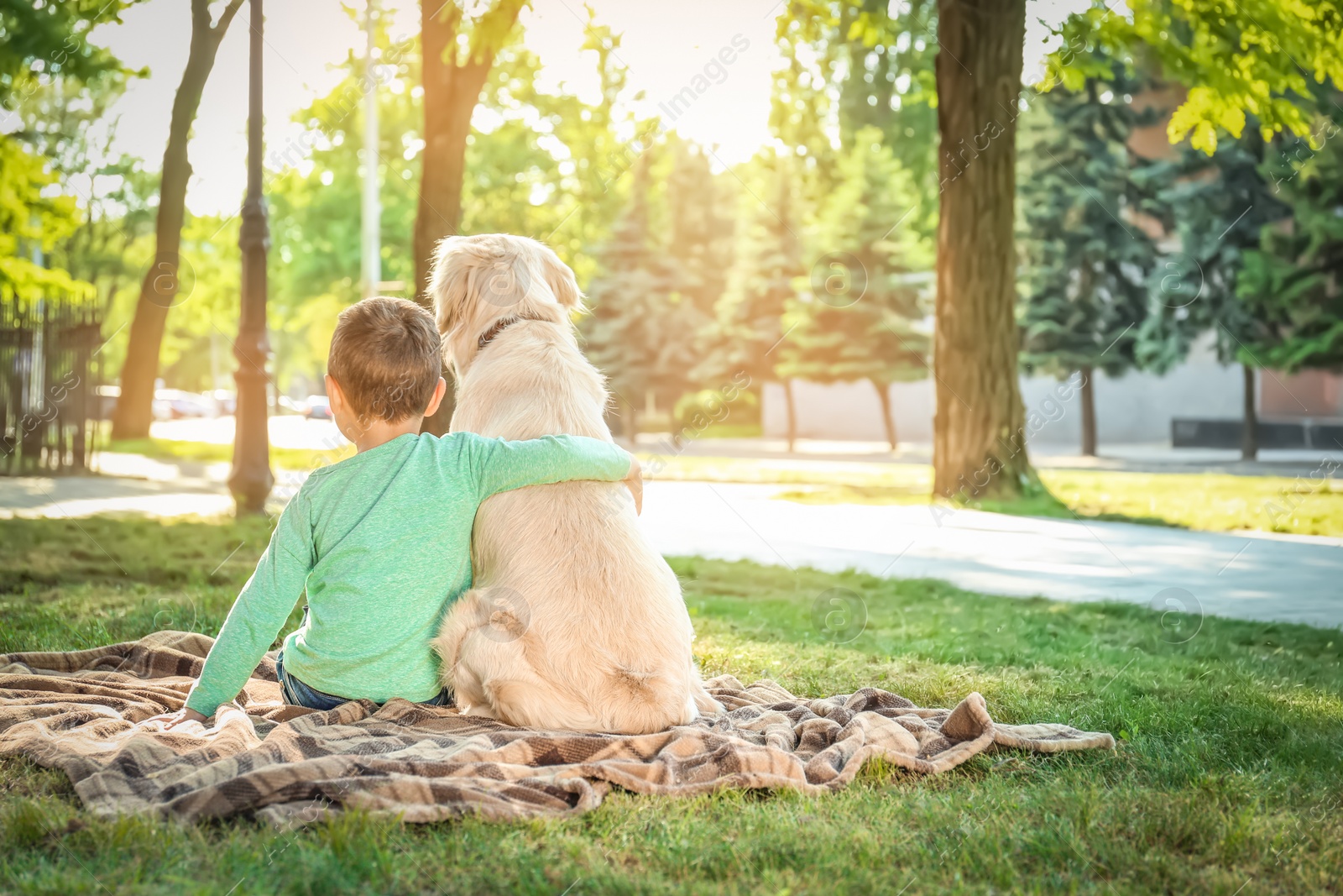 Photo of Cute little child with his pet in green park