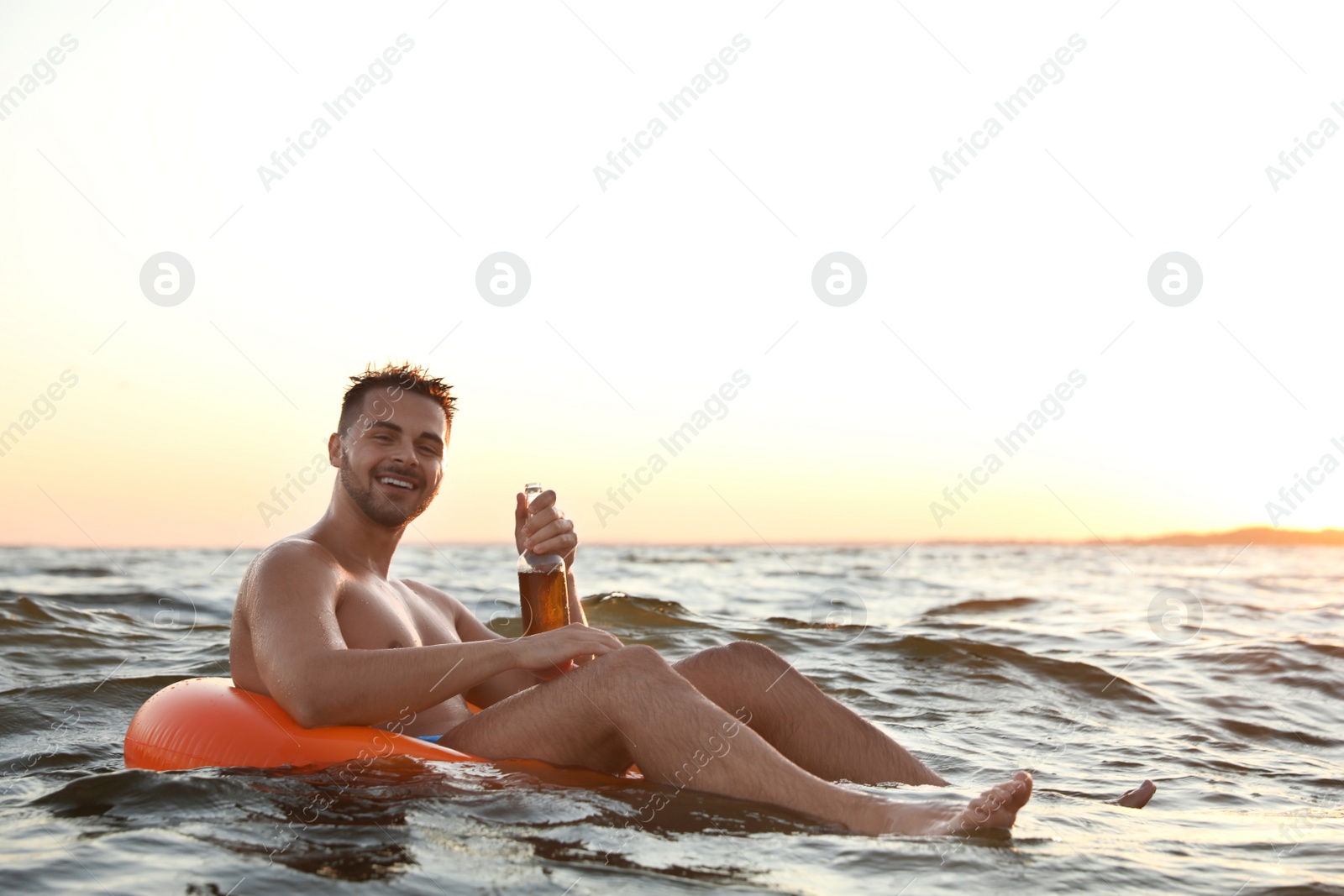 Photo of Happy young man on inflatable ring in water