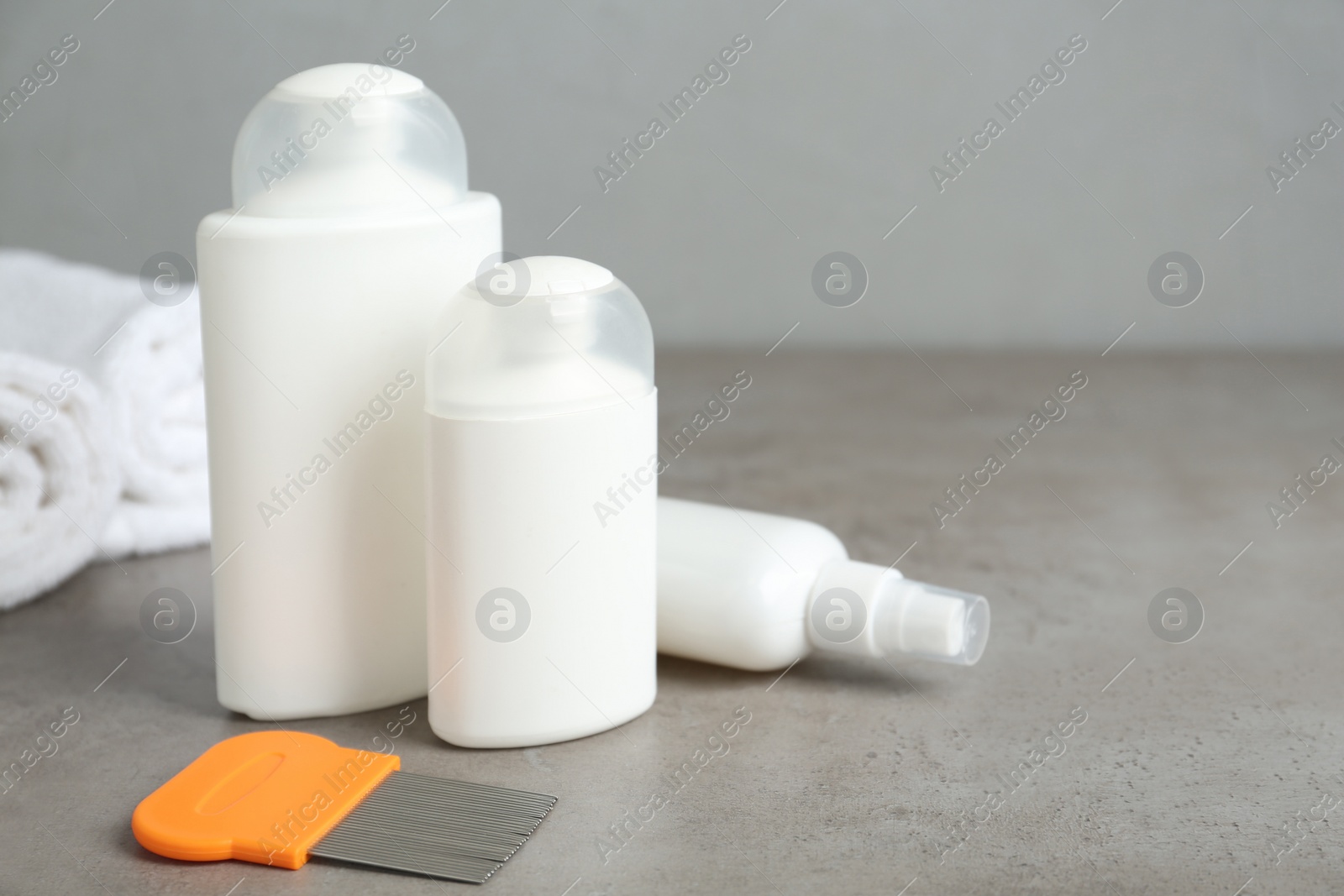 Photo of Different cosmetic products and lice comb on grey table. Space for text