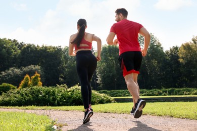 Photo of Healthy lifestyle. Couple running in park on sunny day, low angle view