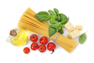 Uncooked spaghetti and ingredients on white background, top view