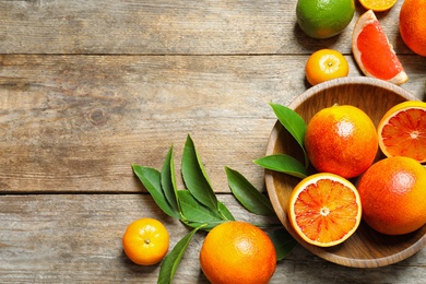 Flat lay composition with different citrus fruits and space for text on wooden background