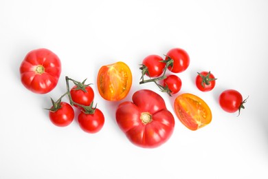 Many different ripe tomatoes on white background, flat lay