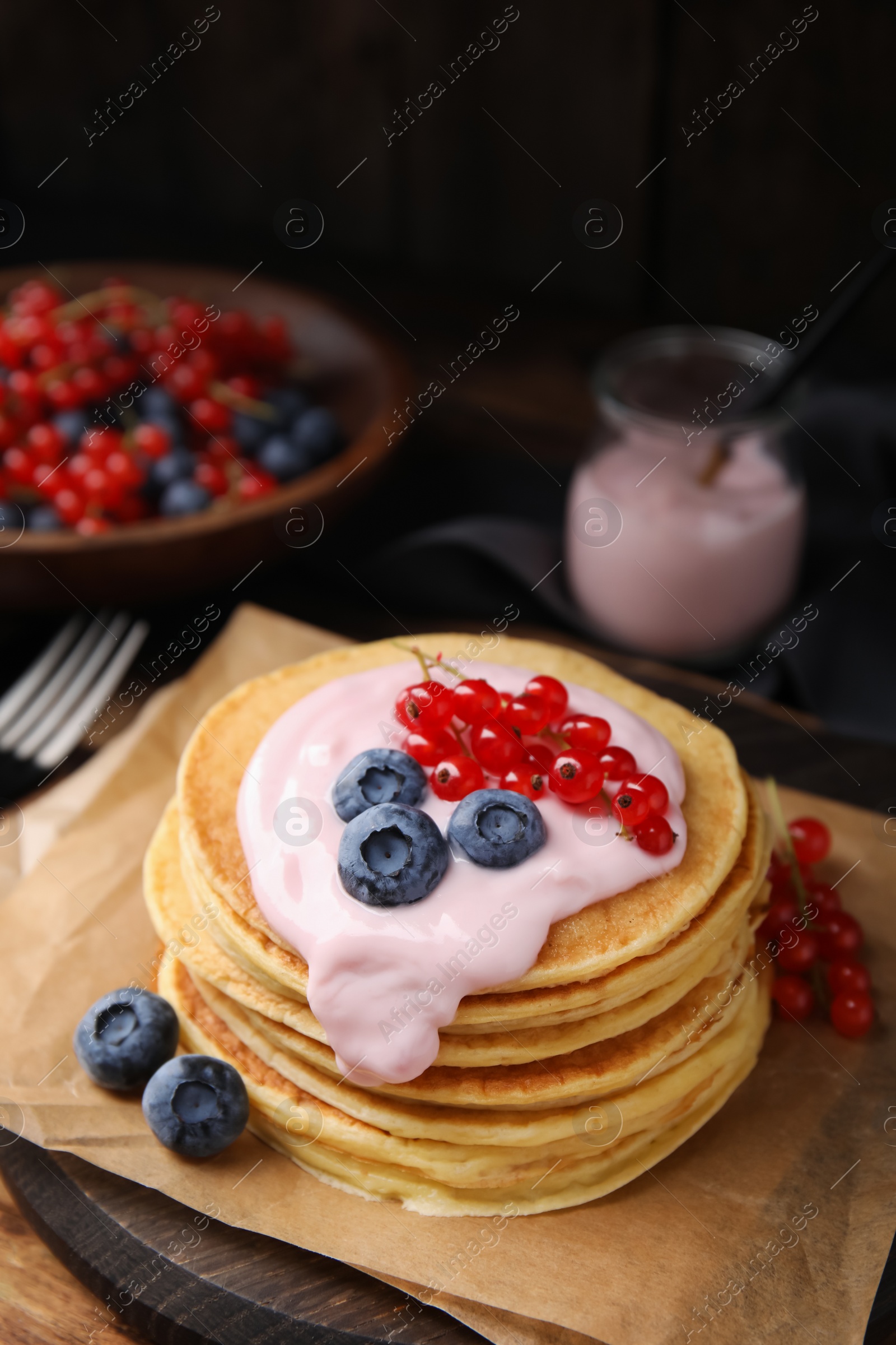 Photo of Tasty pancakes with natural yogurt, blueberries and red currants on table