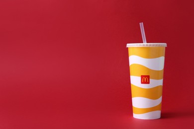 MYKOLAIV, UKRAINE - AUGUST 12, 2021: Cold McDonald's drink on red background. Space for text