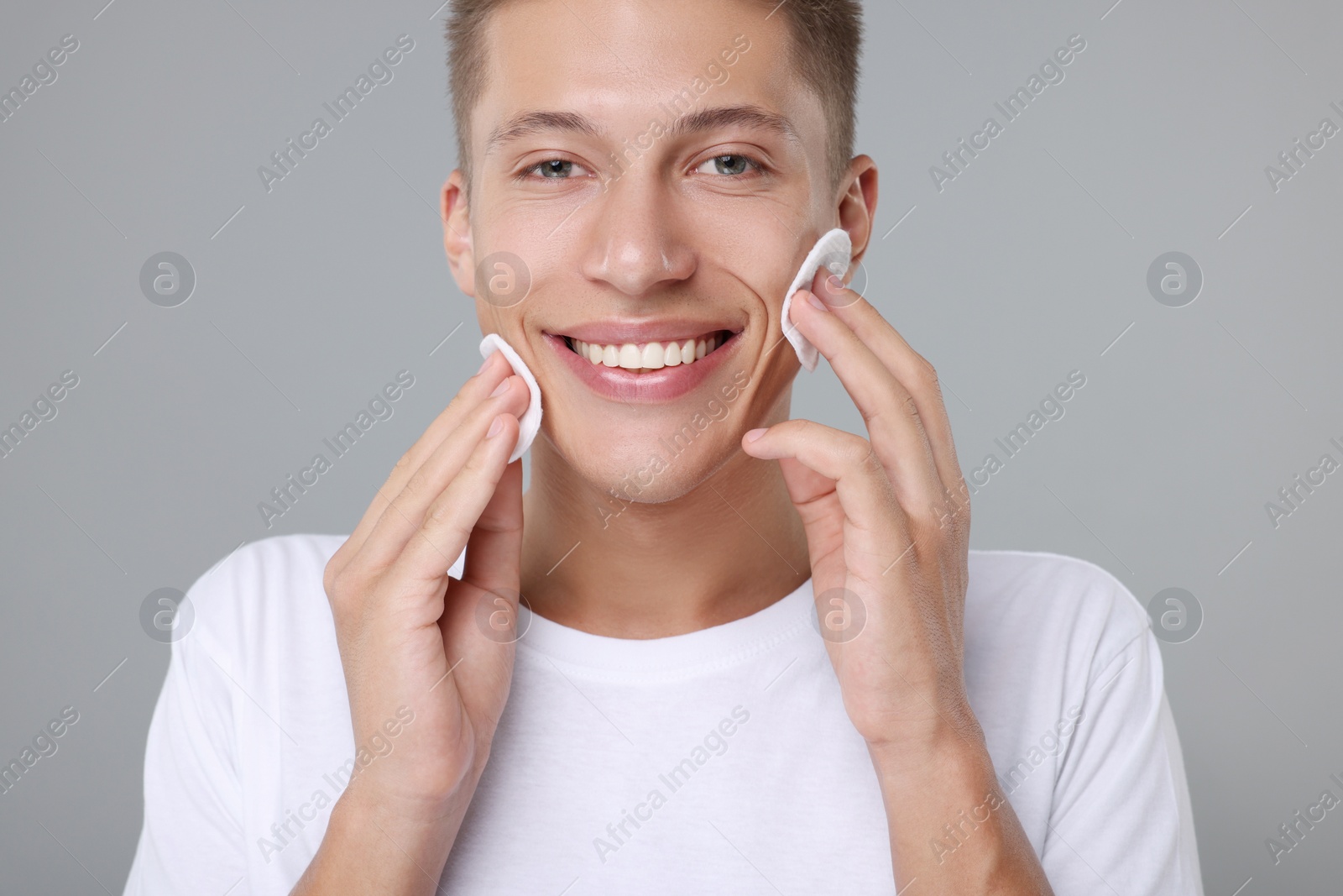 Photo of Handsome man with cotton pads on grey background