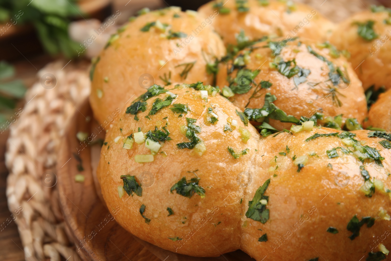 Photo of Traditional pampushka buns with garlic and herbs on plate, closeup