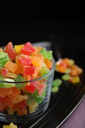 Glass with mix of delicious candied fruits on tray, closeup